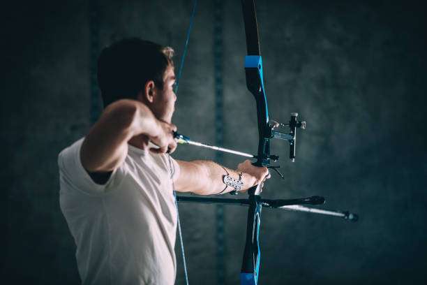 a young boy playing a compound bow