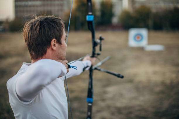 a young boy playing a compound bow