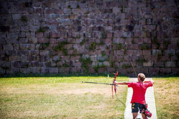 Man with prosthetic arm practicing archery with compound bow