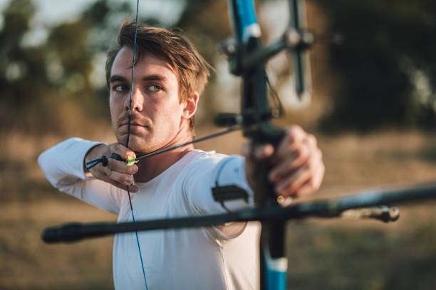 a young boy playing a compound bow
