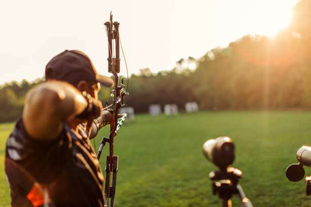 Man with prosthetic arm practicing archery with compound bow