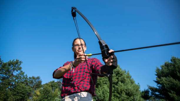 woman with prosthetic arm practicing archery with compound bow