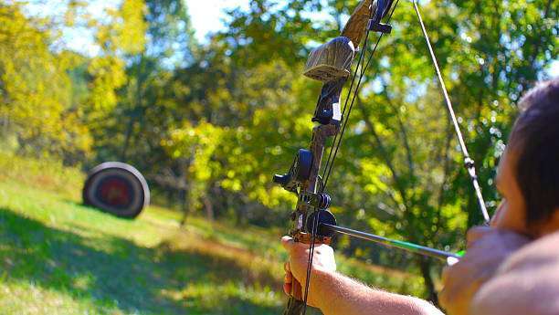 Left-handed man practicing archery with compound bow
