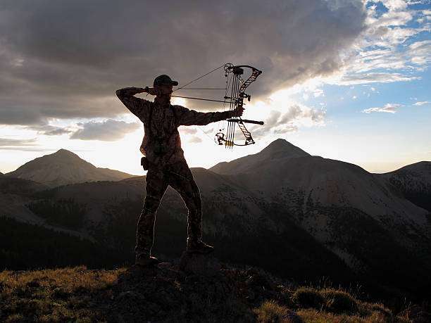 bow hunter silhouette with dramatic landscape,compound bow
