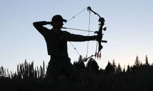 A young female archer with a compound bow