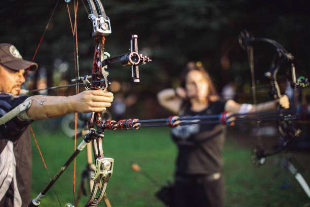 Man with prosthetic arm practicing archery with compound bow