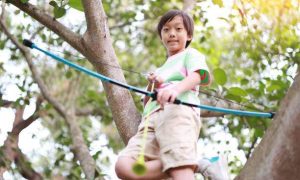 a young boy playing a compound bow