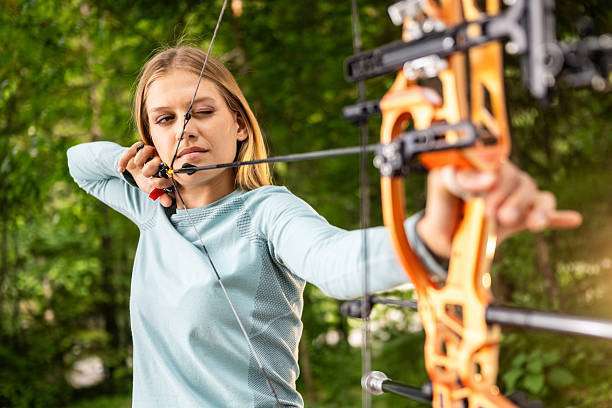 a young boy playing a compound bow