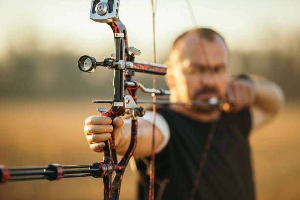 Man with prosthetic arm practicing archery with compound bow