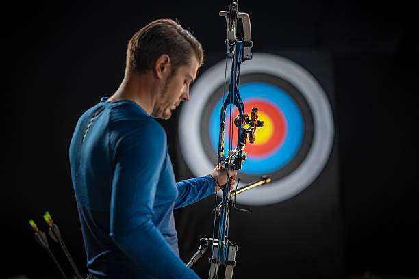 a young boy playing a compound bow