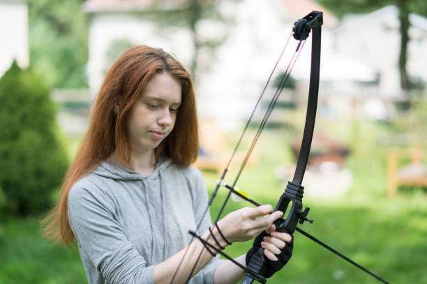 The teenager girl practicing compound bow