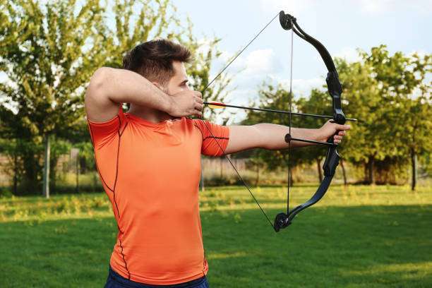 Teenage girl on archery training outdoors. Focus on teenage girl's hands placing arrow.playing a compound bow