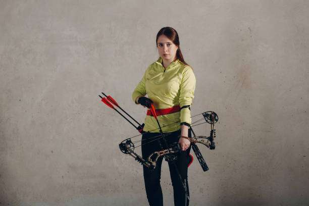 teenage girl's hands placing the arrow. playing a compound bow