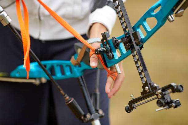 Teenage girl on archery training outdoors. Focus on teenage girl's hands placing arrow.playing a compound bow