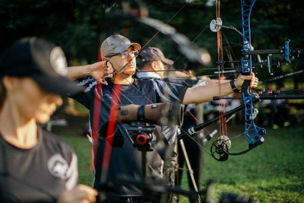 Man competes in archery with a compound bow and sight.